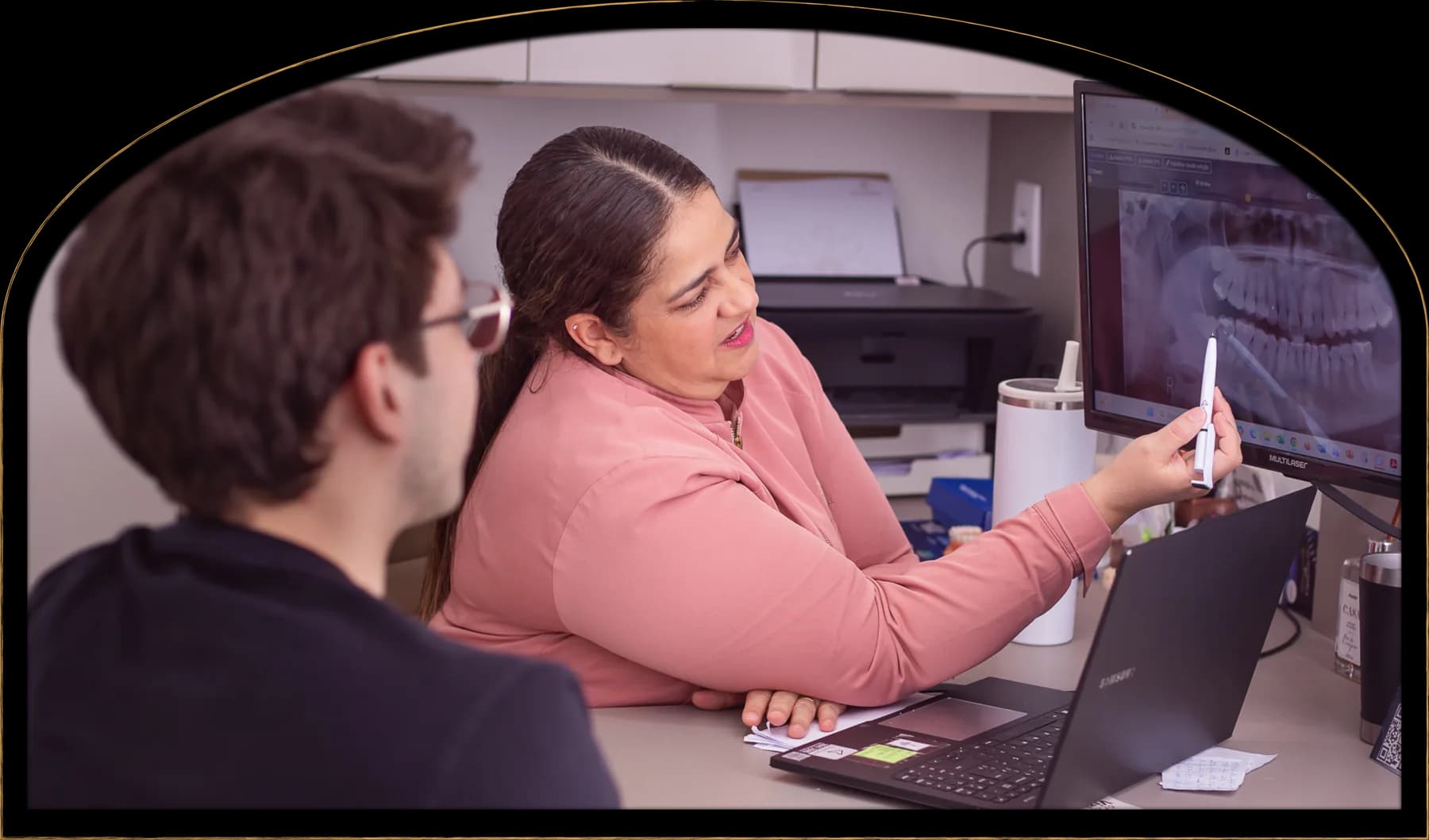 Dra. Cristhiane explicando uma radiografia ao paciente